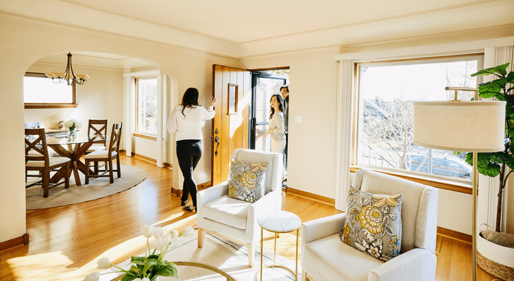 Real estate agent opening door for prospective buyers to enter property for sales